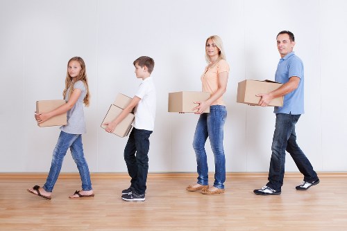 Movers handling furniture carefully inside a property